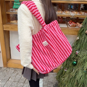 Détail du cabas en peluche à rayures rouges et roses avec texture flanelle douce