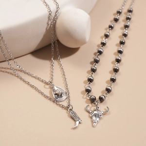Detailed view of Western retro necklaces with cowboy hat, boot, and bull skull pendants