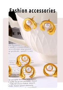 Detail of 18k gold plated C-shaped earrings featuring polished finish and inlaid pearls