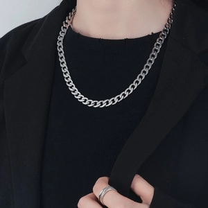 Polished silver stainless steel Cuban link necklace for men and women on model wearing a suit