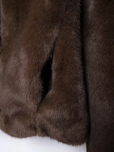 Detailed macro view of dark brown faux fur texture showing soft and silky fibers
