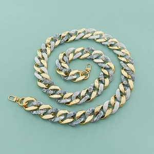 Macro shot of marble resin and gold metal chain links with swivel lobster clasps