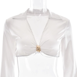 Détail du haut court en satin blanc avec col en V profond et anneau métallique doré
