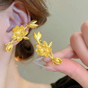 Elegant gold metal flower ear cuff and stud earring set shown on model and held by hand