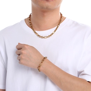 Modello maschile che indossa collana e bracciale a catena ad O dorata in acciaio titanio