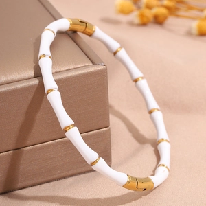 Detailansicht des elfenbeinweißen und goldenen Edelstahl-Armbands im Bambus-Stil auf Schmuckkästchen