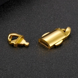 Polished golden stainless steel Cuban chain clasp accessories on a textured black background