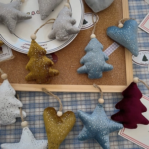 Close-up of plush star and heart Christmas ornaments with gold glitter and wooden beads