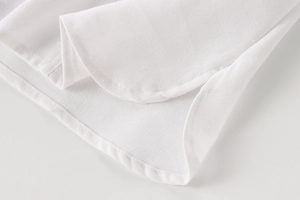 Macro shot of linen blend fabric texture and stitching detail on a white casual shirt