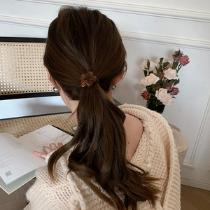 Close-up of amber flower hair tie shown on a ponytail with high-quality resin details