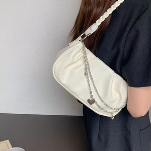 Detail of white PU leather cloud bag with woven handle and silver heart chain