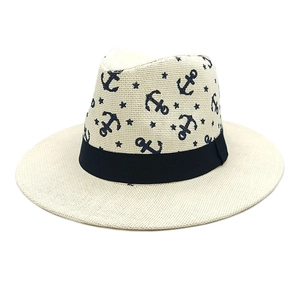 Macro detail of straw fedora hat featuring anchor print and black ribbon band