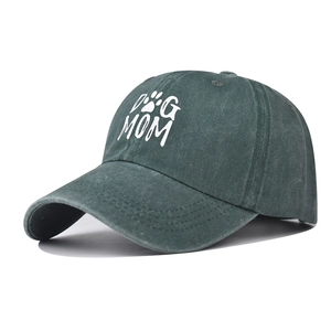 Detail of embroidered DOG MOM logo and paw print on washed dark green baseball cap