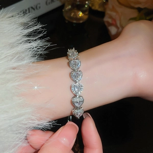 Close-up of sparkling silver heart bracelet with white rhinestones on woman's wrist