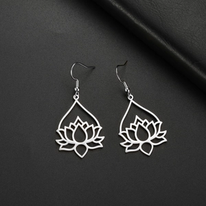 Detailed macro view of silver hollow lotus earrings on premium black leather texture