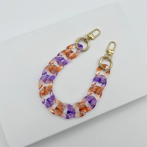Detail der orange-violetten Acryl-Taschenkette mit goldenen Metall-Karabinern