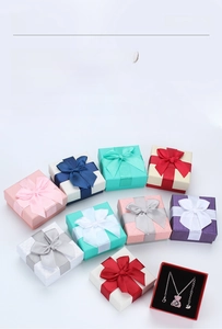 Detailed view of square jewelry gift boxes with ribbon bows and necklace sponge inserts