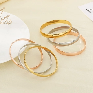 Polished minimalist gold silver and rose gold bangles in a luxury lifestyle display