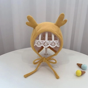 Detail of yellow ribbed knit baby earflap hat with cute reindeer antlers and chin straps