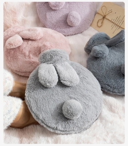 Detailed plush texture of rabbit ear hot water bottles in grey, pink, and purple tones