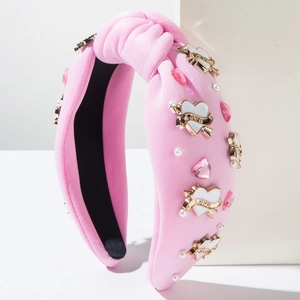Détail du serre-tête noué rose avec cœur LOVE doré, cristaux roses et petites perles blanches