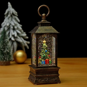 Vintage bronze Christmas lantern with snow globe interior and glowing festive tree