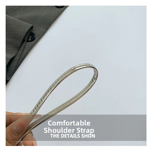 Detail shot of the thin silver metal shoulder strap with precise single-needle stitching