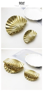 Detailed macro view of gold shell-shaped metal hair claws with glossy finish in two sizes
