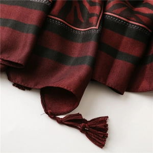 Detailed view of red and black zebra pattern silk scarf with delicate fringe tassels