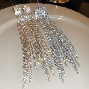 Detail shot of long tassel earrings with sparkling rhinestones in silver and gold finish