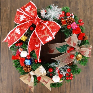 Christmas wreath with reindeer bow and pine cones on dark wood background