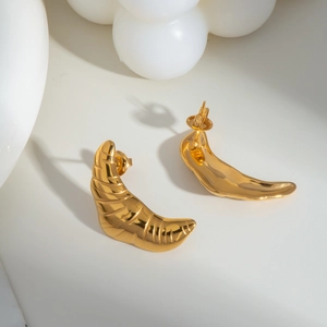 Macro detail of gold croissant hoop earrings showing spiral texture and secure backing
