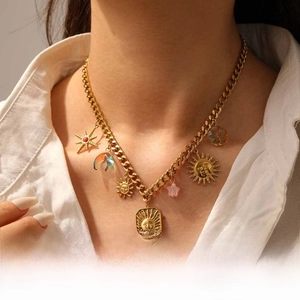 Gold multi-pendant necklace featuring celestial moon, sun and star charms on a model