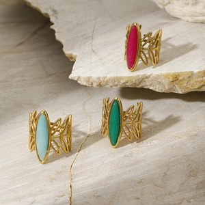 Detailed shot of three gold leaf-etched rings with magenta, green, and blue stones