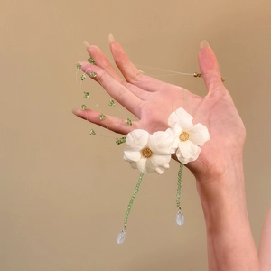 Dettaglio della collana di fiori in tessuto con perle verdi e ciondolo a goccia