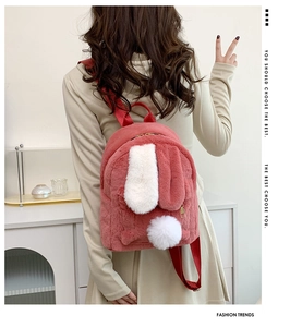 Detail view of pink plush backpack with soft faux fur bunny ears and white pompom tail