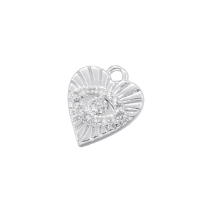 Macro shot of silver heart pendant with crystal eye and sunburst texture detail