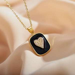 Detail of gold rectangular pendant with black enamel inlay and sparkling zircon heart