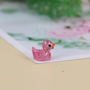 Detailed macro view of a translucent pink resin duck figurine with glitter for DIY gardens