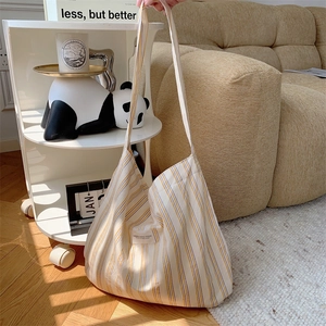 Detail shot of a large striped canvas tote bag in a modern minimalist home setting