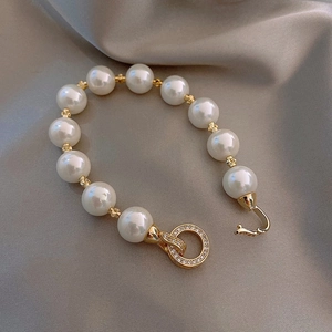 Detailed view of freshwater pearl bracelet with gold spacers on grey satin fabric