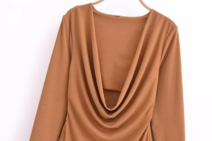 Detail of elegant cowl neck design on a brown long sleeve dress with matte fabric