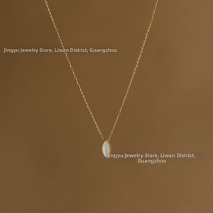 Close-up of gold plated titanium steel necklace with an oval white shell pendant