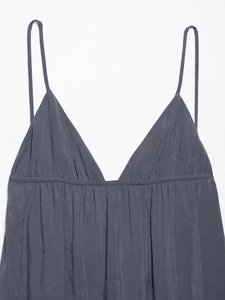 Detail of dark grey V-neck camisole dress featuring pleated satin fabric and thin straps