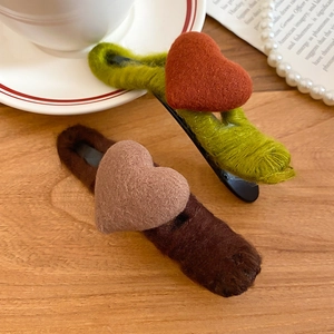 Detailed close-up of handmade acrylic yarn heart hair clips with soft wool felt texture