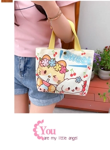 Detail of canvas tote bag featuring cute cartoon cat and bunny print with yellow handle