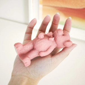 Rosa 3D Teddybär-Kerze mit Fellstruktur und Schleife in der Handfläche gehalten