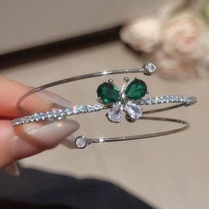 Dettaglio del bracciale a tre strati in argento con farfalla di zirconi verdi e trasparenti