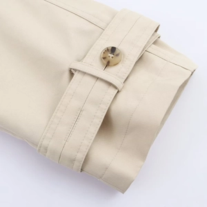Detail of khaki trench coat cuff with tortoiseshell button and fine twill stitching
