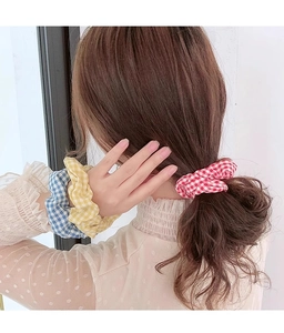 Trois chouchous à motif carreaux présentés comme attaches et accessoires de poignet